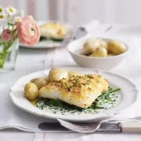 Cheddar-Kruste auf geräuchertem Kabeljau mit Jersey Royals & Crème Fraîche-Sauce