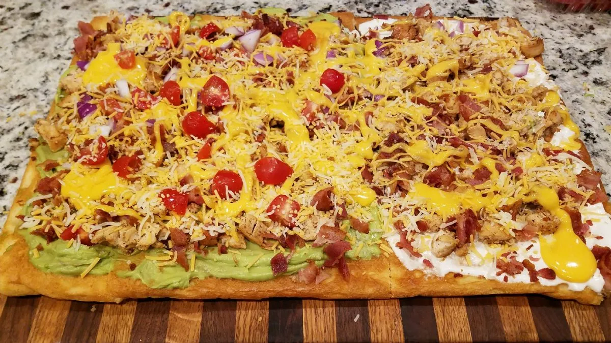 Pizza mit Hähnchen, Speck und Avocado
