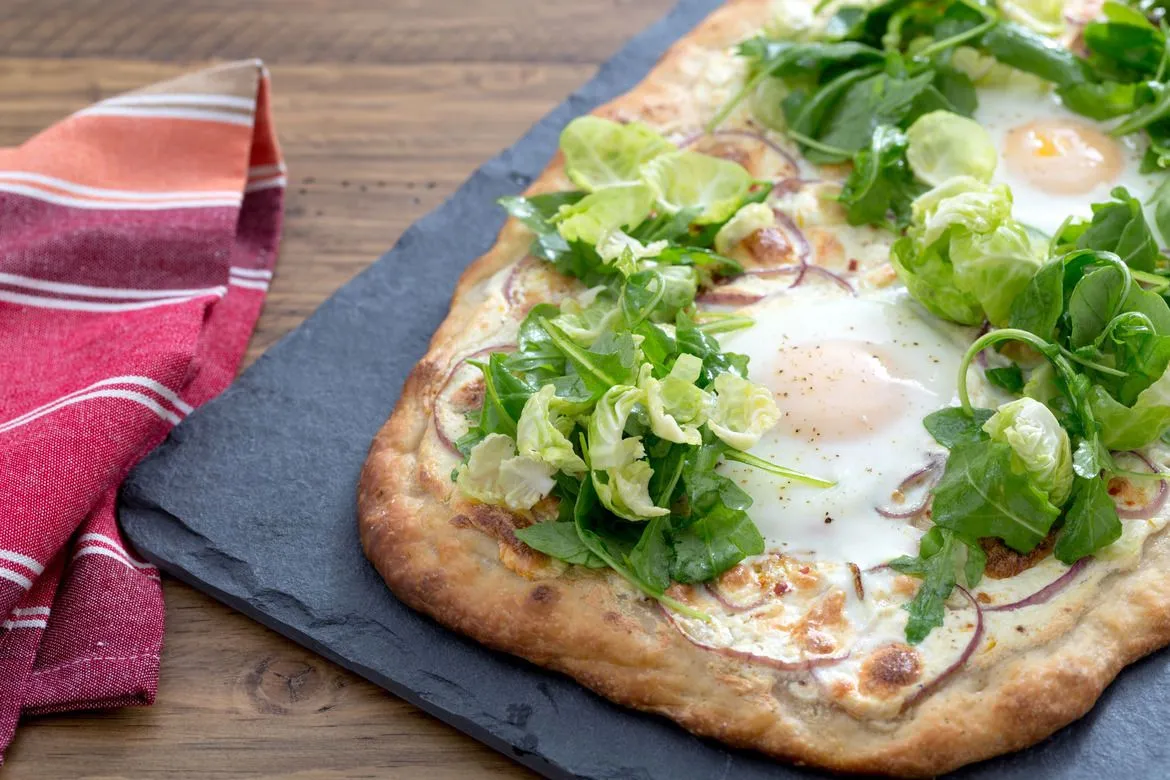 Weiße Pizza mit gebackenen Eiern und Rucola-Brüsseler Sprossen-Salat