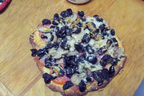 Pizza mit schwarzen Oliven und Champignons